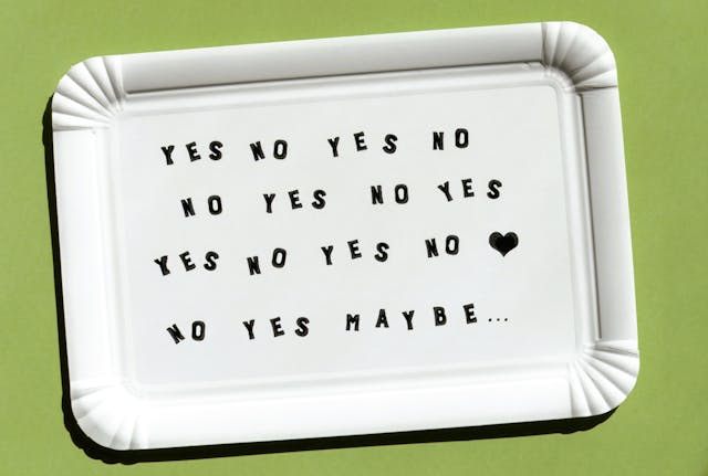 Kartonnen onderzetter met herhaling van 'YES NO YES NO', een hartje en 'maybe' – symboliseert de vraag: ben je klaar om te daten na een relatiebreuk of nog niet?